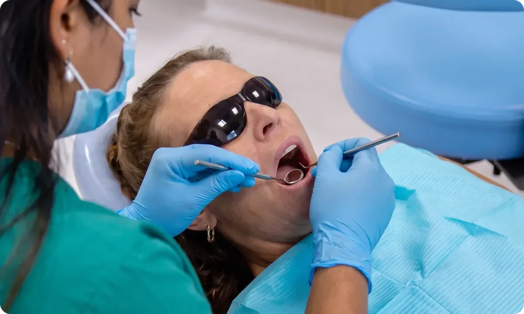 Dentist examining a patient's teeth with a dental mirror at Carina Gardens Dental, Carina Brisbane