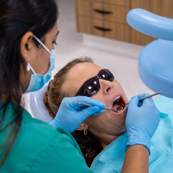 Dentist examining a patient's teeth with a dental mirror during a restorative dentistry check at Carina Gardens Dental, Carina Brisbane